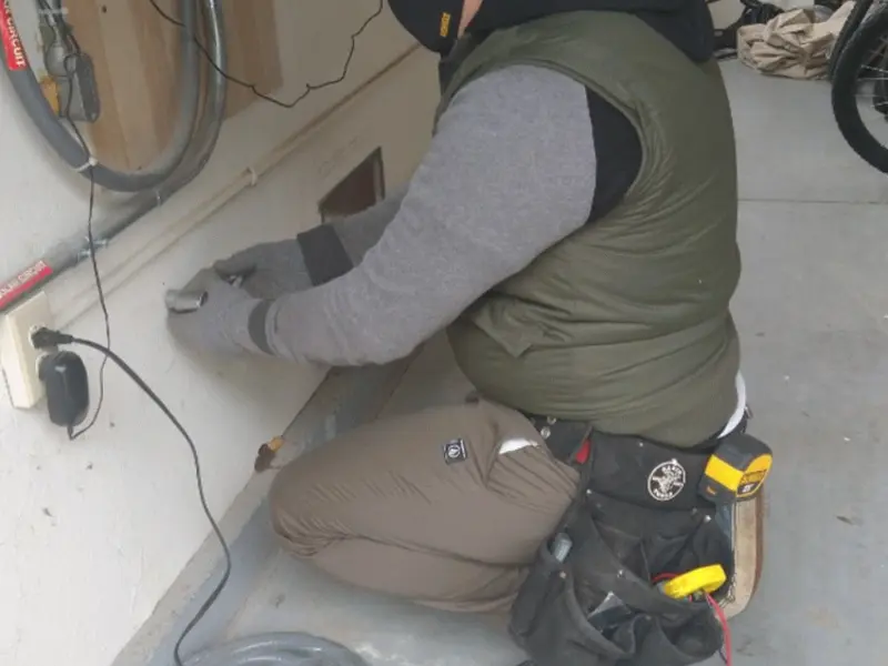 Electrician performing outlet wiring in a Beloit garage